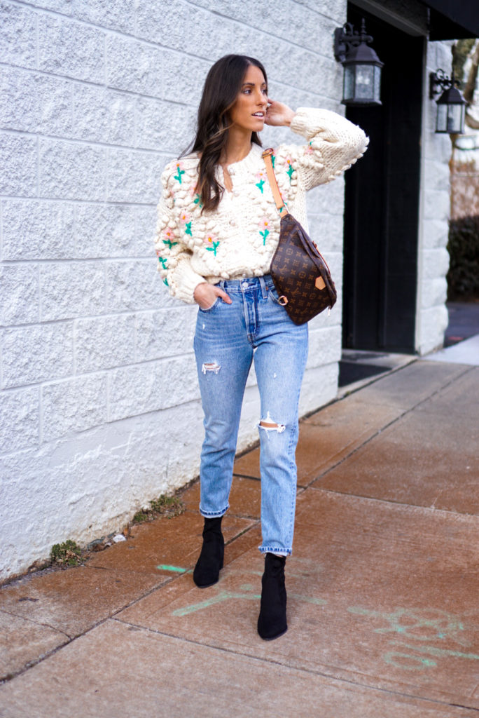 Women wearing high waisted mom jeans with chunky knit sweater and ankle booties