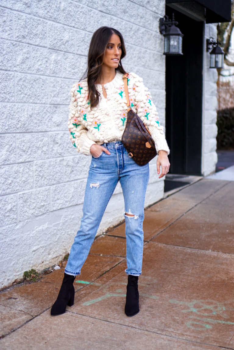 Women wearing light blue mom jeans with chunky knit sweater