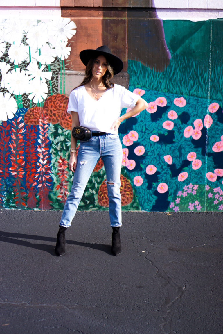 Woman wearing basic white t-shirt that is cropped with distressed mom jeans