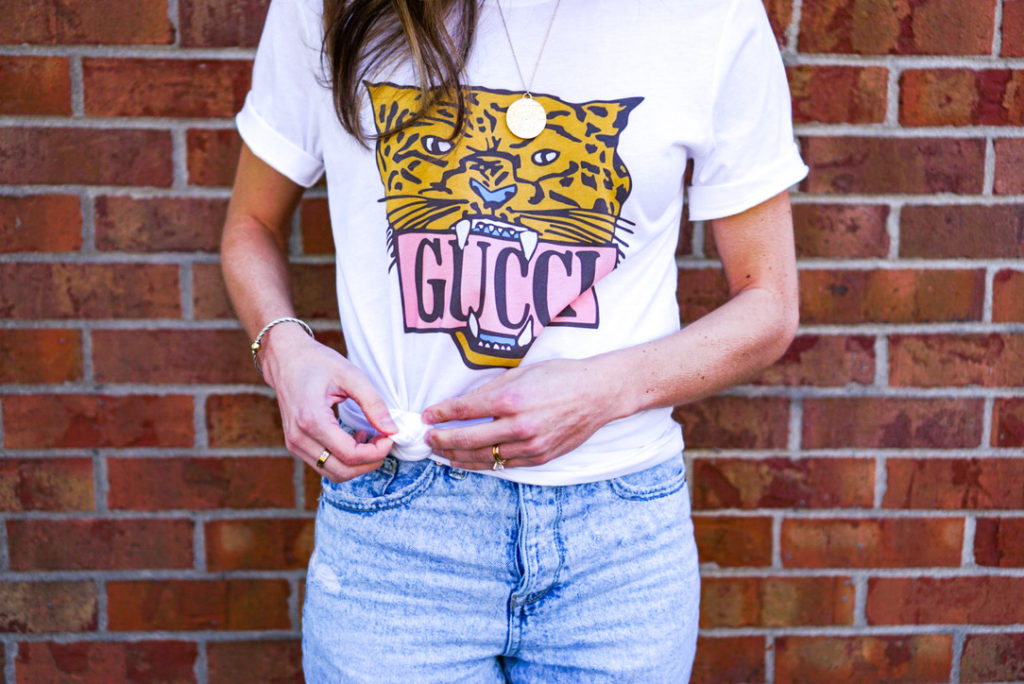 woman showing you how to side knot a gucci t shirt